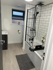 La salle de bains est pourvue d'une douche, d'une fenêtre et d'un miroir. dans l'établissement Hugo House, à Poole