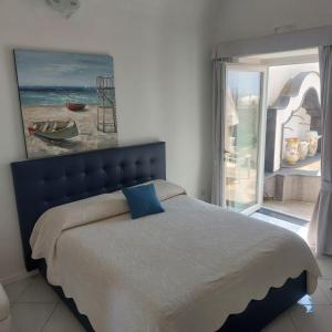 a bedroom with a bed with a painting on the wall at Villa Tesoro in Positano