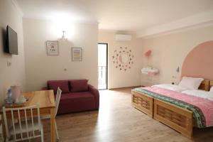 a bedroom with a bed and a couch and a table at hOlarooms N1 in Sachure