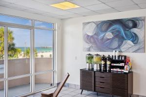 una habitación con una mesa con botellas de vino y una ventana en Holiday Terrace Beachfront Hotel, a By The Sea Resort, en Panama City Beach