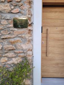 a sign on a stone wall next to a door at Boutique Athensairport Apartments in Markopoulo