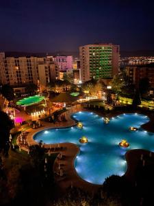 ein großer Wasserpool in einer Stadt in der Nacht in der Unterkunft ROYAL BEACH & APARTAMENT in Sonnenstrand