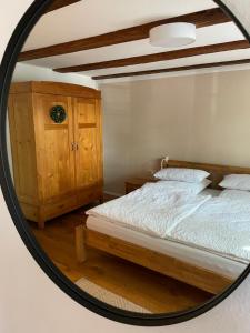 a mirror reflecting a bedroom with a bed and a cabinet at Dreher Hof Salem in Salem