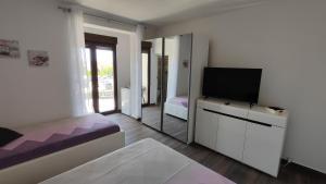 a bedroom with a bed and a tv and a mirror at Viktor rooms and apartments in Rovinj