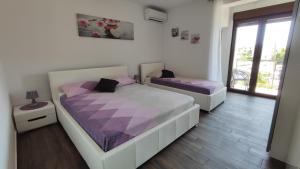 a bedroom with two beds with purple sheets at Viktor rooms and apartments in Rovinj +70 photos