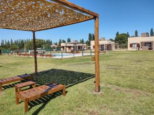 ein Park mit zwei Bänken unter einem Baldachin in der Unterkunft Buenas Tierras Cabañas in San Rafael