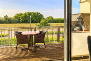 eine Terrasse mit einem Tisch und Stühlen auf einer Terrasse in der Unterkunft Villa Deichgraf 12 "Meerblick" in Börgerende-Rethwisch