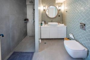 un bagno con un water, un lavandino e uno specchio di Mi Casa Su Casa a Città di Kos Altre 25 foto