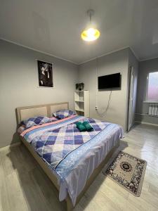 a bedroom with a bed with a tv on the wall at Day and Night II in Tokolʼdosh