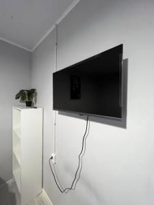 a flat screen tv hanging on a white wall at Day and Night II in Tokolʼdosh