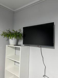 a flat screen tv on a white entertainment center at Day and Night II in Tokolʼdosh