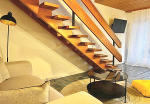 ein Wohnzimmer mit einer Treppe, einem Sofa und einem Tisch in der Unterkunft Maisonettewohnung Steinbock mit Bergblick in Bayrischzell