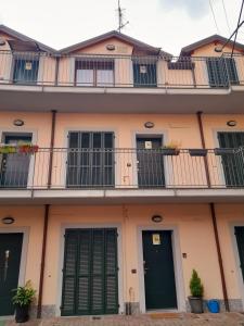 A Casa di Sole Arese في أريسي: مبنى شقق بأبواب خضراء وبلكونات