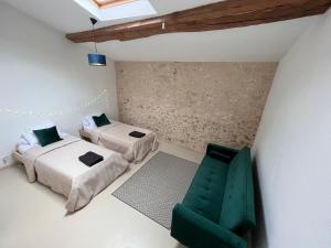 a room with two beds and a green chair at No 10 Vic Fezensac in Vic-Fezensac