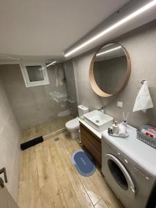 een badkamer met een wastafel, een toilet en een spiegel bij Seaside Archontiko in Arkondikó