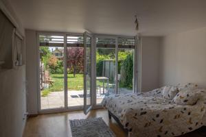 Schlafzimmer mit einem Bett und einer Glasschiebetür in der Unterkunft Auberge de La Couronne in Mies