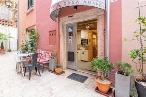 różowy budynek ze stołem i krzesłami przed nim w obiekcie Casa Amando Eco Boutique House w Rovinj