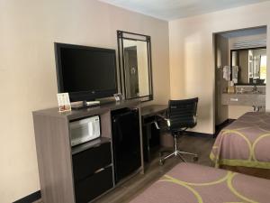 a hotel room with a desk with a television and a bed at Super 8 by Wyndham Chattanooga/East Ridge in Chattanooga