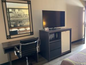 a hotel room with a television and a mirror at Super 8 by Wyndham Chattanooga/East Ridge in Chattanooga
