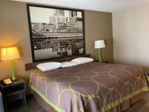 a hotel room with a bed with a large picture on the wall at Super 8 by Wyndham Chattanooga/East Ridge in Chattanooga