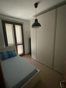 ein Schlafzimmer mit einem Bett und einer Hängeleuchte in der Unterkunft Appartamento indipendente con terrazzo e giardino in Vasto