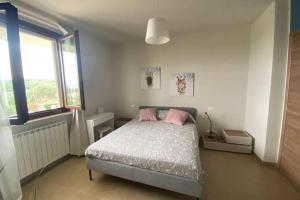 ein Schlafzimmer mit einem Bett mit zwei rosa Kissen in der Unterkunft Appartamento indipendente con terrazzo e giardino in Vasto