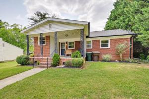 a brick house with a porch and a lawn at Greensboro Vacation Rental 2 Mi to Downtown! in Greensboro