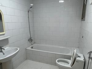 y baño con bañera, aseo y lavamanos. en Hakimdom Hostel, en Riad