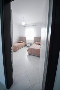 a room with two beds and a window at Vila Kokoneshi in Divjakë