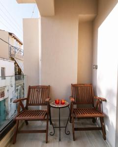 two chairs and a table on a balcony at Central apartments “Evanthia” in Pitsidia