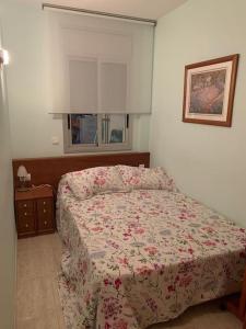 um quarto com uma cama com um edredão florido em Apart. en 1ra línea+pkg privado em Sant Antoni de Calonge