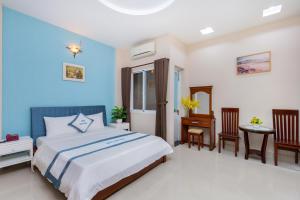 a bedroom with a bed and a table and chairs at Queen Garden Hotel & Apartment in Vung Tau