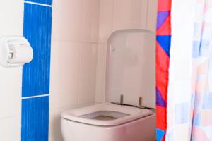 La salle de bains est pourvue de toilettes et d'un rideau de douche coloré. dans l'établissement Taste of Mexico Hostel, à Dar es Salaam
