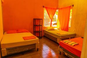 Cette chambre comprend 3 lits et une fenêtre. dans l'établissement Casa grande Monterrico, à Monterrico