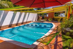 - une vue sur la piscine avec un parasol dans l'établissement Casa grande Monterrico, à Monterrico