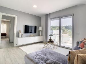 a living room with a tv and a large window at Rancho Tá-Mar Apartment Nazaré Beach in Nazaré