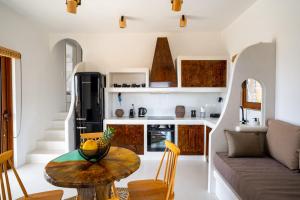 a kitchen and living room with a table and a couch at Saint Nicholas Resort - Villas in Kithnos
