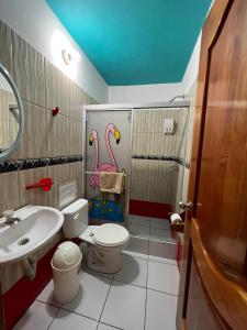 łazienka z toaletą i umywalką w obiekcie Hostal Brisas Del Mar w mieście Puerto Villamil