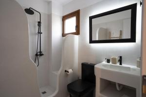 y baño con lavabo, ducha y espejo. en Saint Nicholas Resort - Villas en Kíthnos