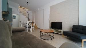 un soggiorno con divano, TV e tavolo di Incanto Luxury House a Párga