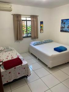 1 dormitorio con 2 camas y ventana en Pousada das Flores., en Boa Vista