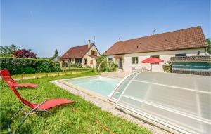 a red chair and a swimming pool in a yard at Stunning Home In Briare With Outdoor Swimming Pool, Wifi And Sauna in Briare