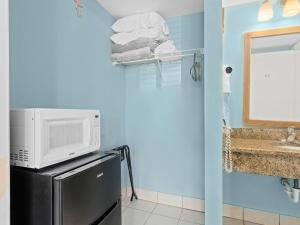 a microwave on top of a refrigerator in a bathroom at Laguna Reef #119 - Simpatico in Rockport