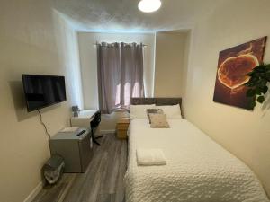 a small bedroom with two beds and a television at Earls street Scotstoun, Glasgow in Whiteinch