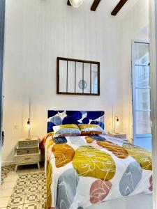 una camera da letto con un grande letto con un copriletto colorato di Picasso's Tres Puertas 4 bedrooms a Málaga
