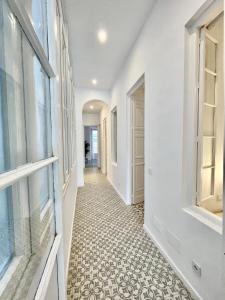 un corridoio di una casa con pareti bianche e pavimento piastrellato di Picasso's Tres Puertas 4 bedrooms a Málaga