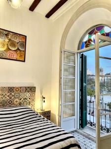 1 dormitorio con cama y ventana grande en Picasso's Tres Puertas 4 bedrooms en Málaga