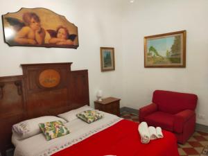 sypialnia z czerwonym łóżkiem i czerwonym krzesłem w obiekcie Casa in palazzo Graffeo Sven w mieście Palermo