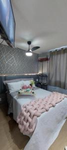 ein Schlafzimmer mit einem großen Bett mit einer rosa getufteten Decke in der Unterkunft Sp Bras, Apartamento inteiro, Expo Center Norte, Vinho Grátis, feira da madrugada, Rua vautier, Rua 25 de março, Templo, Pari in São Paulo