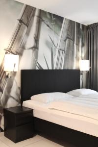 a bedroom with a bed and two lamps on a wall at Super Stay Hotel, Oslo in Oslo